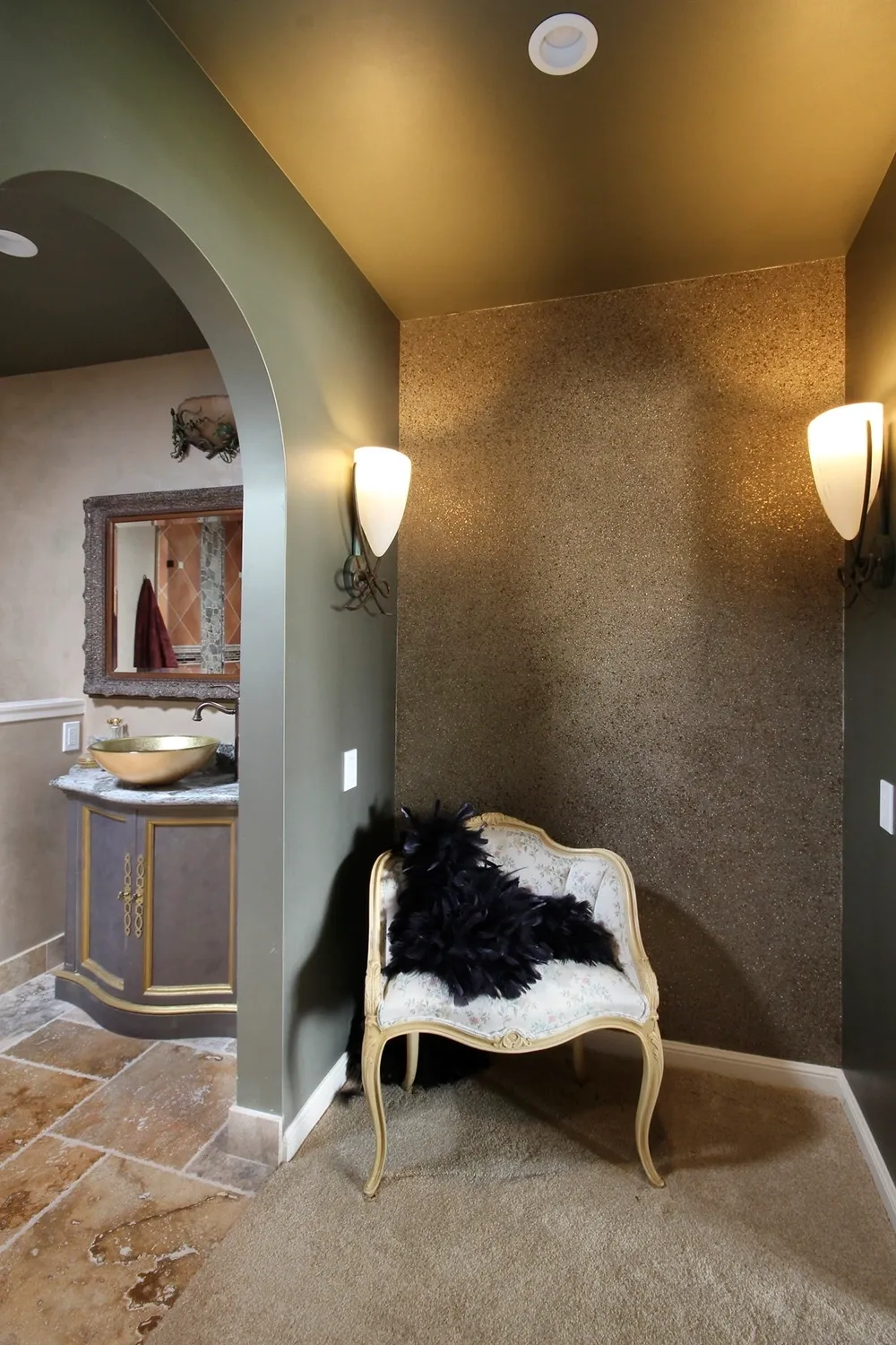 Elegant bathroom entryway with an arched doorway and gold textured accent wall.